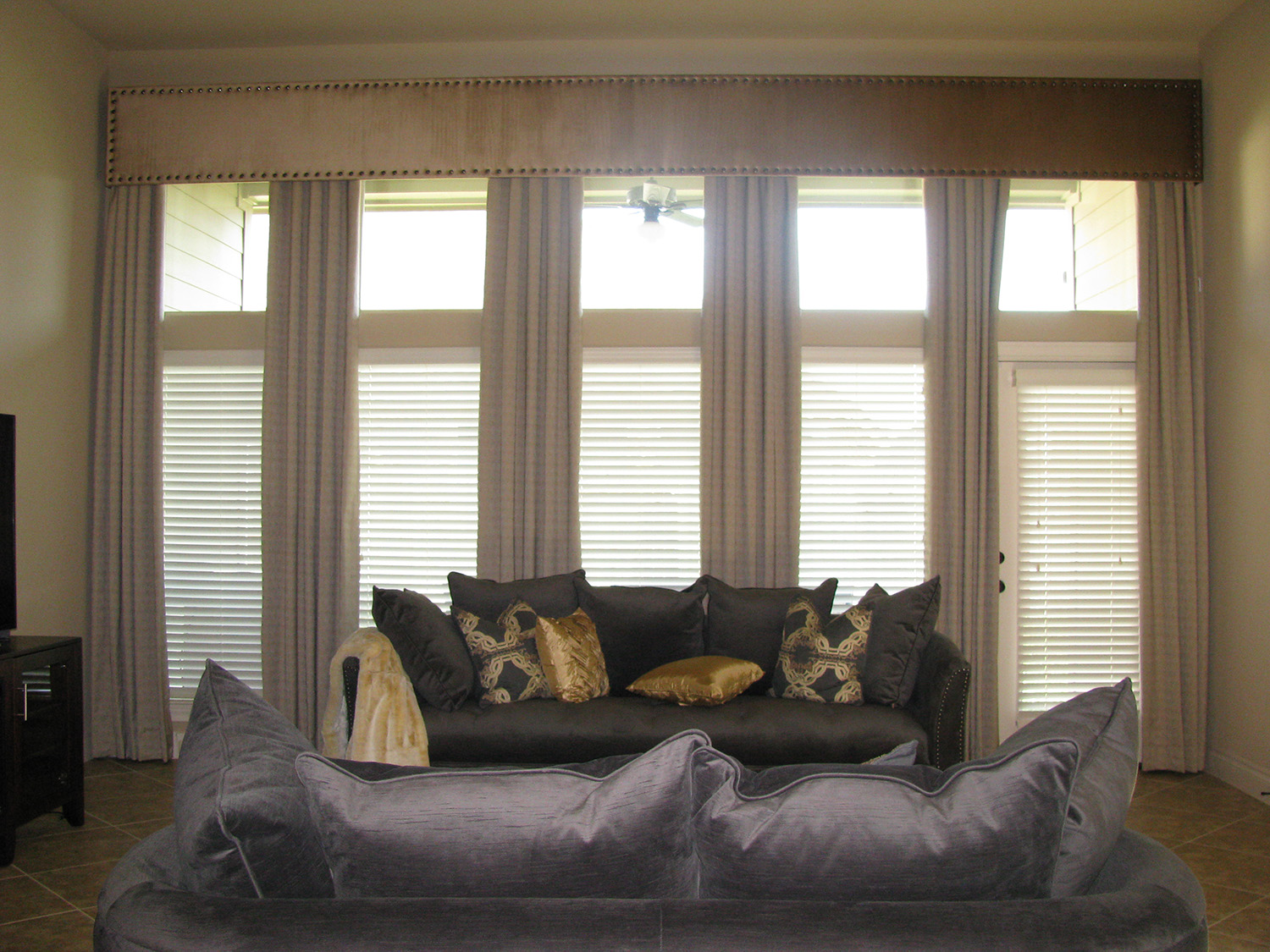 cream drapes with blinds hung on window with silver couch